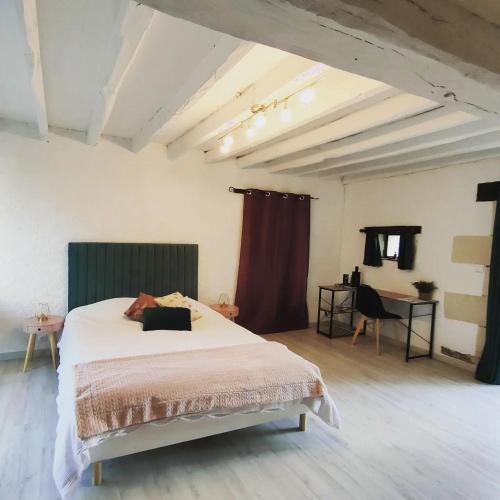 une chambre avec un grand lit et une table dans l'établissement Chambre d'hôtes des Gâtines, à Berthegon