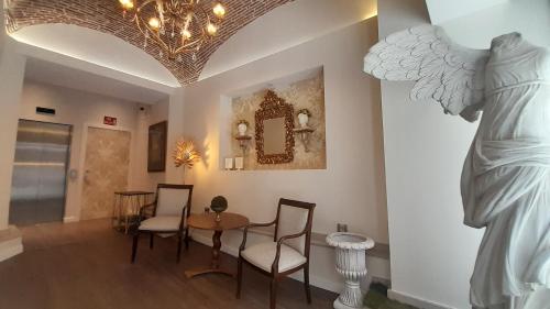 a living room with a table and a statue at Olivae Hostal Boutique in Cáceres
