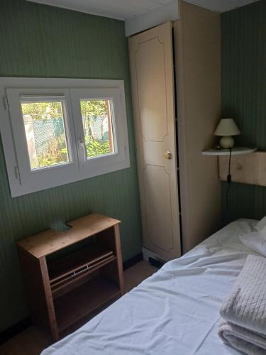 une chambre avec un lit et une fenêtre dans l'établissement MH 16 LA TREMBLADE, à La Tremblade
