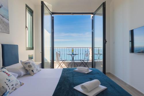 a bedroom with a bed and a balcony with a view at Villa Krstac in Budva