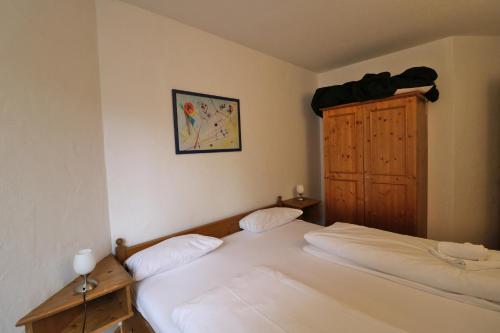 1 dormitorio con 2 camas y armario de madera en Fewo 12 - Residenz Schauinsland, E-Ladestation, Todtnauberg, Feldberg, en Todtnauberg