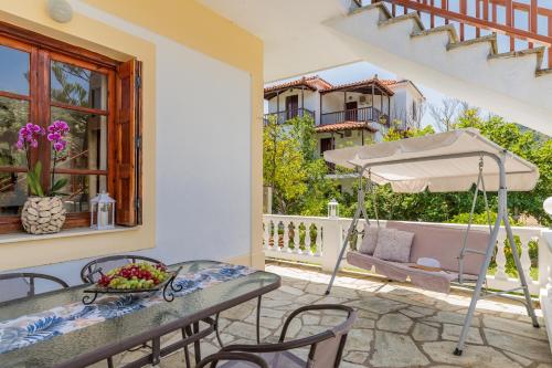 a patio with a table and an umbrella at Panagou Studios in Skopelos Town