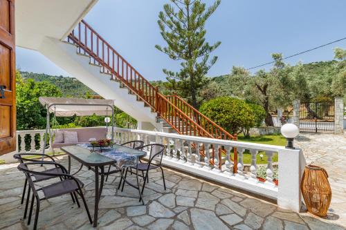a patio with a table and chairs and a staircase at Panagou Studios in Skopelos Town