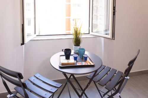 a table with two chairs and a tray of food at Partenope Guest House in Naples