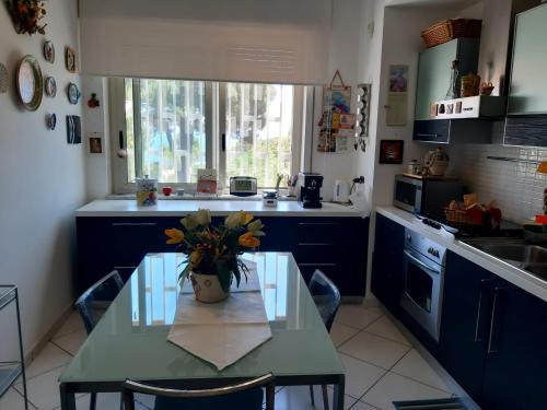 eine Küche mit einem Tisch und einer Blumenvase darauf in der Unterkunft Dilly Home Holiday-Casa vacanze in Aci Castello