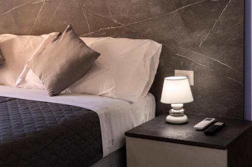 a bedroom with a bed with pillows and a table with a lamp at Partenope Guest House in Naples