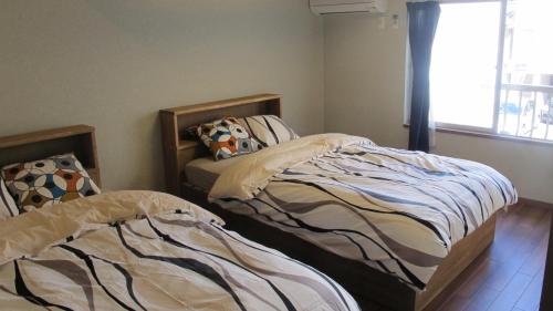 two beds sitting next to each other in a bedroom at Kyoto Gion Shinbashi-an in Kyoto