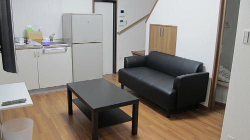 a living room with a black couch and a table at Kyoto Gion Shinbashi-an in Kyoto