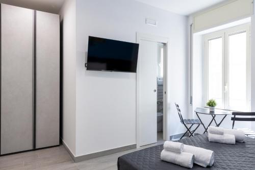 a living room with a bed and a tv on a wall at Partenope Guest House in Naples