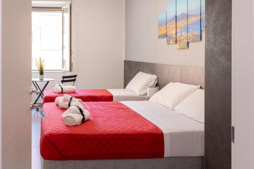two beds in a room with red and white at Partenope Guest House in Naples