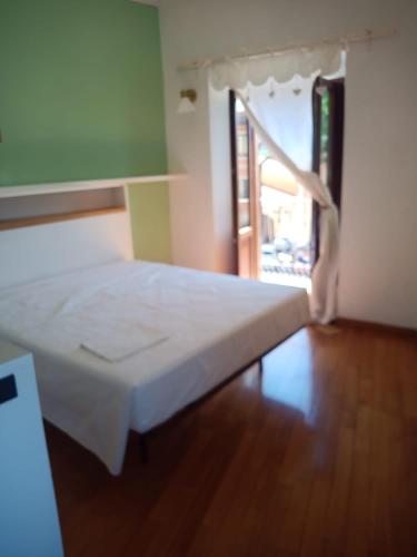 a white bed in a room with a window at Oasi in Poggio Moiano