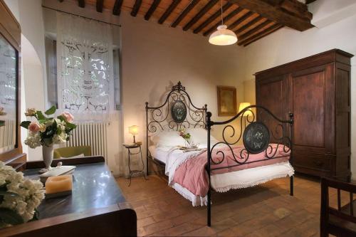 um quarto com uma cama grande e uma mesa em allegretti agriturismo em Castelnuovo Berardenga