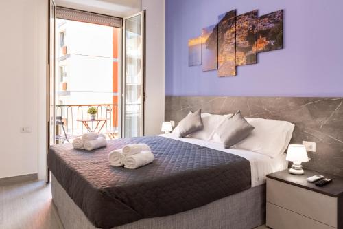 um quarto com uma cama grande e toalhas em Partenope Guest House em Nápoles