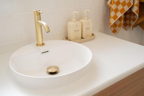 a white sink with two soap bottles on a counter at Luxury hideaway holiday unit in CBD in Mount Gambier