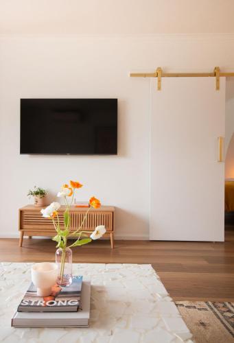a living room with a tv and a vase on a book at Luxury hideaway holiday unit in CBD in Mount Gambier