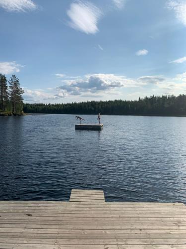 a person standing on a dock in a lake at In the middle of Trysilfjellet - Welcome Center - Apartment with 3 bedrooms - By bike arena and ski lift in Trysil