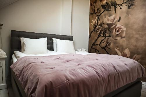a bedroom with a bed with a pink blanket at Ludvigsdal Semesterboende in Ystad