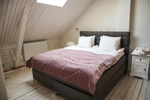 a bedroom with a large bed with white pillows at Ludvigsdal Semesterboende in Ystad