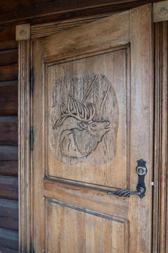 a wooden door with a drawing of a cat on it at Lyxigt timmerhus i fjällen, Lofsdalen, Hjortehytta in Lofsdalen