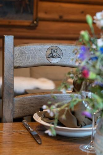a wooden table with a plate of flowers on a chair at Lyxigt timmerhus i fjällen, Lofsdalen, Hjortehytta in Lofsdalen