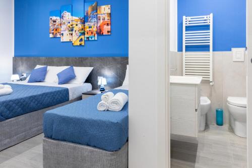 um quarto de hotel com duas camas e uma casa de banho em Partenope Guest House em Nápoles