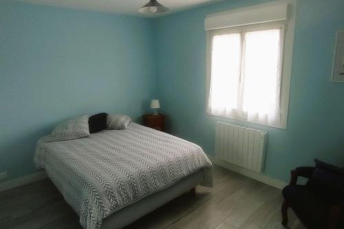 een blauwe slaapkamer met een bed en een raam bij Maison tout confort avec jardin in Cayeux-sur-Mer