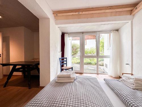um quarto com uma cama, uma mesa e uma janela em Giebelblick A em Oberstaufen