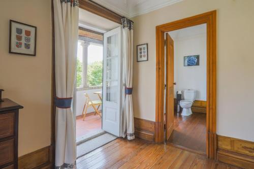 pasillo con puerta que da a un baño con aseo en Outeiro Tuías - Manor House, en Marco de Canaveses