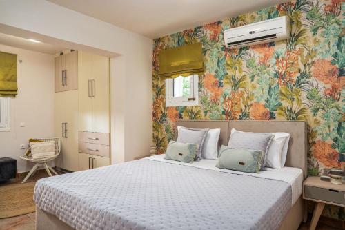 una camera da letto con un grande letto e carta da parati floreale di Suburban Elegant Studios a Città di Zante
