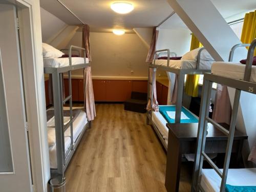 Zimmer mit 3 Etagenbetten in einem Schlafsaal in der Unterkunft Room Mate Hostel Amsterdam Zaandam in Zaandam