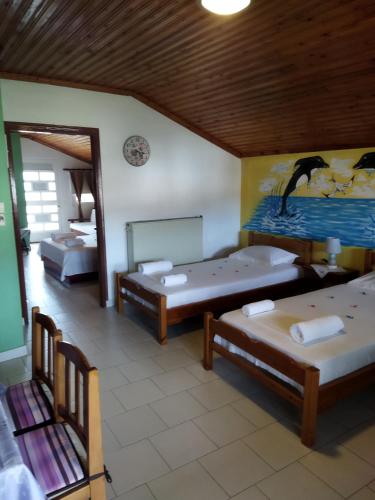 a room with two beds and a painting on the wall at Katia's Apartments in Sarti