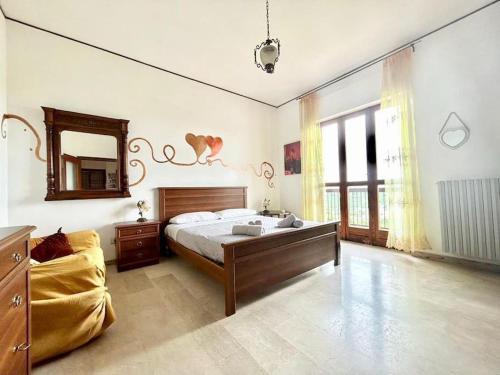 a large bedroom with a bed and a mirror at Al Belvedere vista Langhe in Benevello