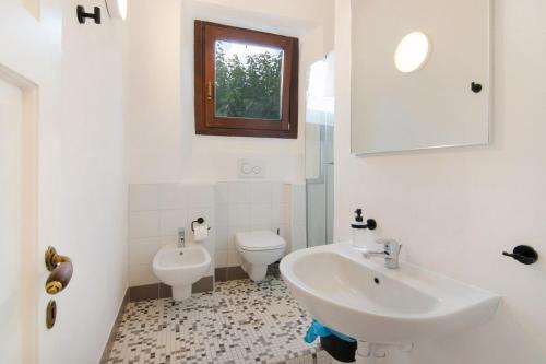 ein weißes Bad mit einem Waschbecken und einem WC in der Unterkunft Workation Castle - Casa Tremezzo in Carlazzo