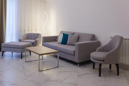 a living room with a couch and two chairs and a table at Aparthotel Pietroasa in Buzău