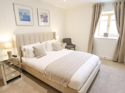 Un dormitorio con una gran cama blanca y una ventana en The Grange Cottage 1, en Grimsby