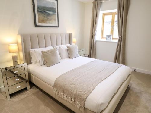 a bedroom with a large white bed with a window at The Grange Cottage 2 in Grimsby