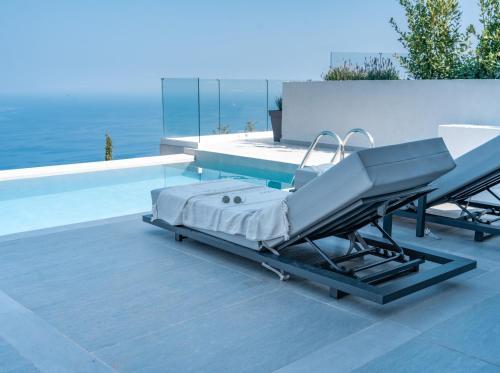 a massage bed on a patio next to a swimming pool at Anadeo Villas & Suites in Exanthia