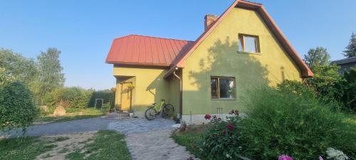 una casa gialla e verde con una bicicletta davanti di Brīvdienu māja Koknesē a Koknese