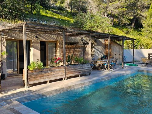 ein Haus mit einer Bank neben einem Pool in der Unterkunft MAS DE LA FADETO in Les Baux-de-Provence