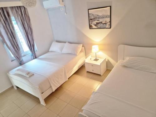 una piccola camera da letto con due letti e una finestra di Sala apartment's a Sarandë