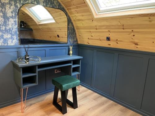 Habitación con escritorio y taburete verde. en Wonderland Retreats en Carnforth