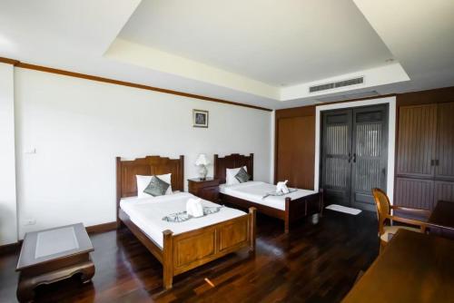 ein Hotelzimmer mit 2 Betten und einem Tisch in der Unterkunft Kooncharaburi Resort - Koh Chang in Ko Chang