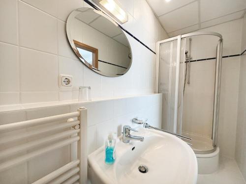 a white bathroom with a sink and a mirror at Pension Zur Inselbrücke in Wolgast