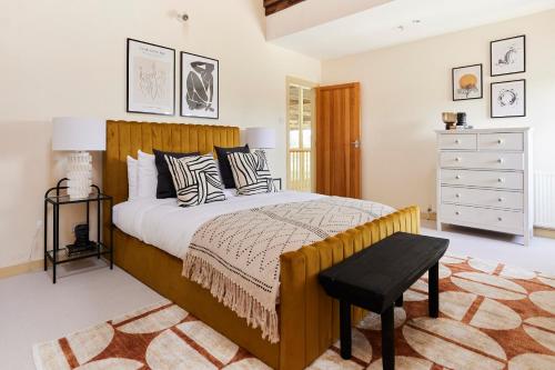 um quarto com uma cama grande e uma cómoda em The Chelmsford Hideaway - Spacious 5BDR House with Patio + Garden em Chelmsford