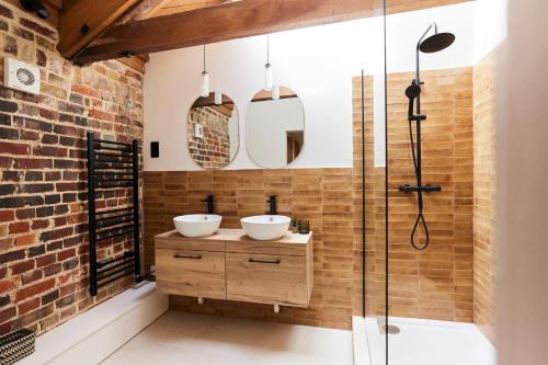 a bathroom with two sinks and a shower at The Chelmsford Hideaway - Spacious 5BDR House with Patio + Garden in Chelmsford