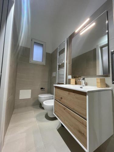 a bathroom with a sink and a toilet and a mirror at Terra De Mare in Palmariggi