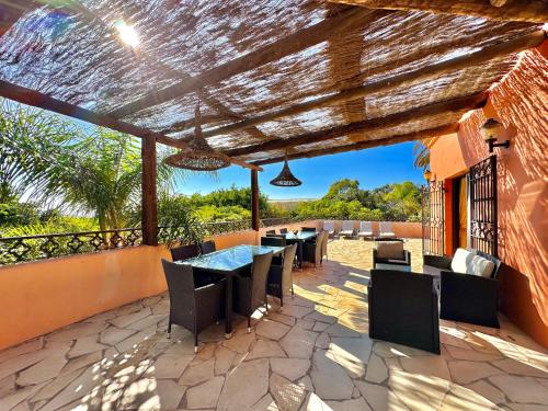 un patio al aire libre con mesa y sillas en Tropical Garden Finca en Guía de Isora