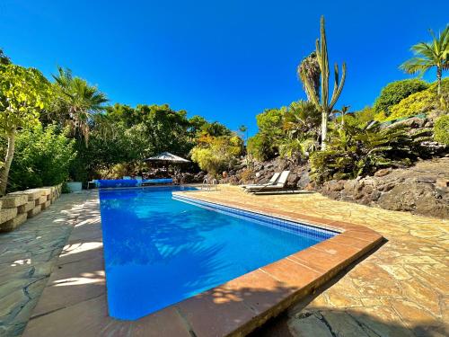 a swimming pool with blue water in a resort at Tropical Garden Finca in Guía de Isora