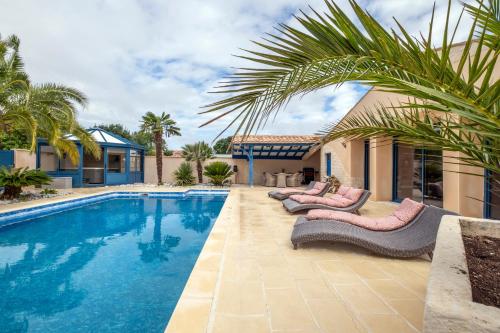 une piscine avec des chaises longues à côté d'une maison dans l'établissement Villa Boyard - Pour 10 avec piscine privée et jacuzzi, à Saint-Nazaire-sur-Charente