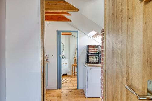 un couloir avec une cuisine et une porte menant à une chambre dans l'établissement Le Verlaine - appt charmant cosy idéalement situé, à Calais